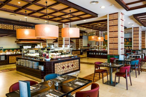 Innenansicht des Restaurants im H10 Estepona Palace mit Buffet und gedeckten Tischen.