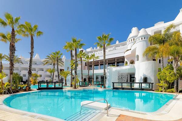 Außenbereich des H10 Estepona Palace Hotels mit Swimmingpool und Palmen.