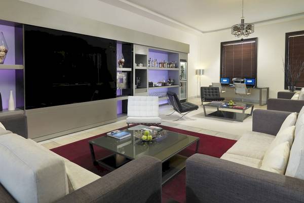 Modernes Wohnzimmer im H10 Estepona Palast mit großen Sofas, Tisch, Fernseher und Dekor.
