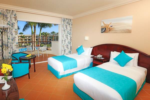 Zimmer im LABRANDA Royal Makadi Hotel mit zwei Betten, Aussicht auf Terrasse und Pool.