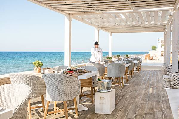Außenrestaurant des Grecotel LUX ME White Palace mit Blick auf das Meer.