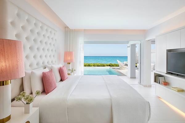 Schlafzimmer im Grecotel LUX ME White Palace mit Blick auf den Ozean und modernem Design.