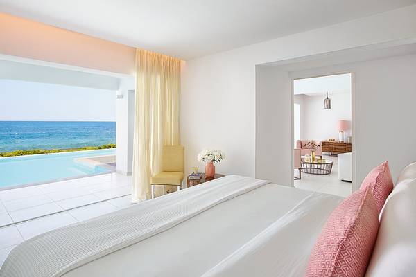 Schlafzimmer im Grecotel LUX ME White Palace mit Blick auf das Meer.