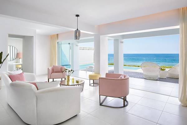 Wohnzimmer des Grecotel LUX ME White Palace mit Blick auf das Meer.