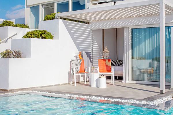 Außenbereich des Grecotel LUX ME White Palace Hotels mit Terrasse, Sesseln und Pool