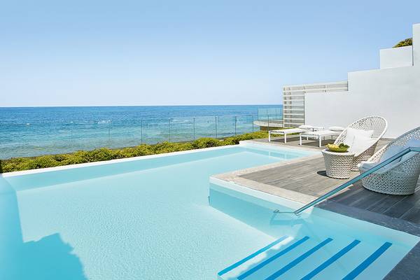 Infinity-Pool des Grecotel LUX ME White Palace mit Blick auf den Ozean.