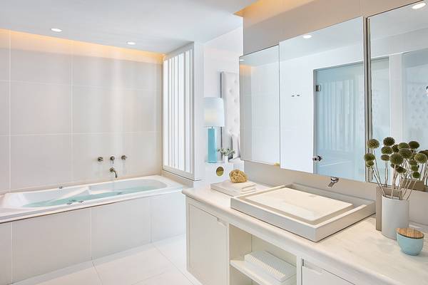 Ein modernes Badezimmer mit einer Badewanne, einem Waschbecken und einem großen Spiegel.