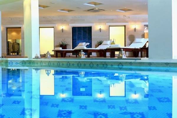 Apollonia Beach Resort & Spa Schwimmbad mit Liegen und Beleuchtung