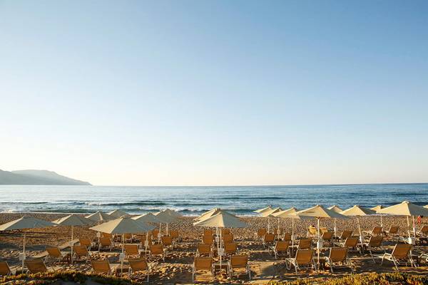 Strand des Orpheas Resorts mit vielen Sonnenschirmen und Liegestühlen am Meer