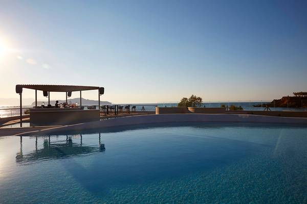 Pool-Ansicht des Domes Noruz Chania, Autograph Collection mit Bar und Blick auf das Meer.