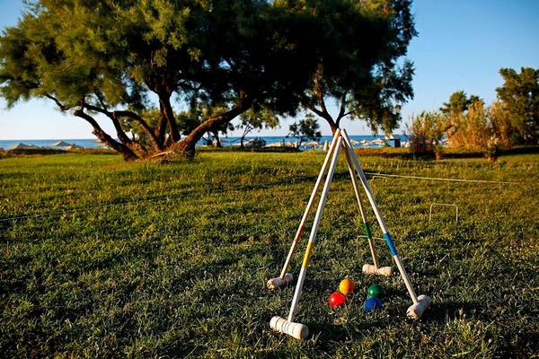 Croquet-Spielplatz im Freien im Orpheas Resort mit Blick auf das Meer und Bäume.