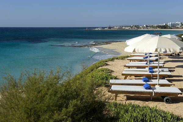 Strand mit Liegen und Sonnenschirmen im Grecian Sands Hotel