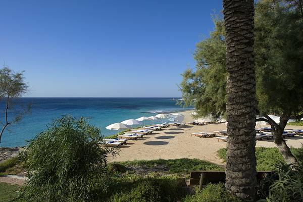 Griechischer Sand Strand im Griechenland mit Sonnenliegen und Sonnenschirmen