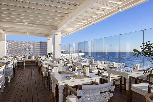 Außenterrasse des Grecian Sands Hotels mit Blick auf das Meer