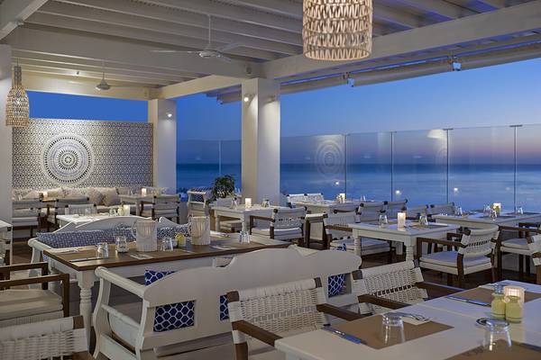 Innenansicht des Restaurants auf der Terrasse des Grecian Sands Hotels mit Blick auf den Ozean.