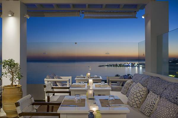 Aussicht von der Terrasse des Grecian Sands Hotels mit Blick auf den Ozean und die Stadt bei Sonnenuntergang.
