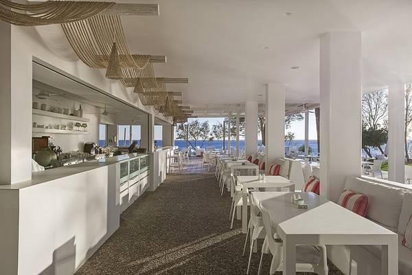 Innenansicht des Restaurants im Grecian Sands Hotel mit Blick auf das Meer.