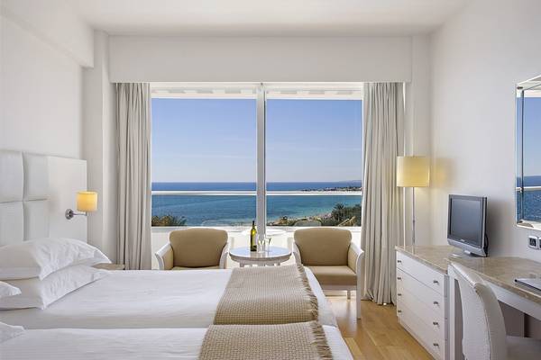 Doppelzimmer im Grecian Sands Hotel mit Meerblick und moderner Einrichtung.