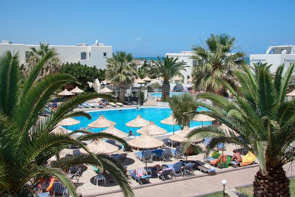 Aussenbereich des Europa Beach Hotel & Spa mit Pool und Liegestühlen unter Palmen