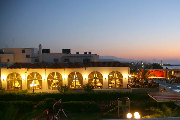 Abendansicht des Europa Beach Hotel & Spa mit beleuchtetem Gebäude und Pool.