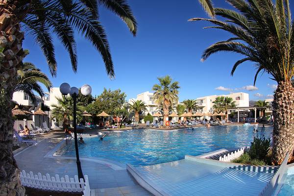Außenpool des Europa Beach Hotel & Spa mit Palmen und Sonnenschirmen.