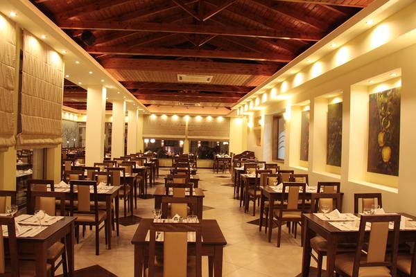 Innenbereich des Restaurants im Europa Beach Hotel mit gedeckten Tischen und dekorativen Gemälden an den Wänden.