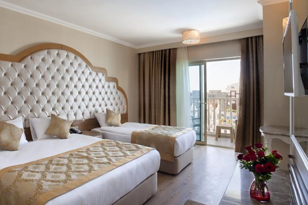 Hotelzimmer von Oz Hotels Side Premium mit zwei Betten, einem gepolsterten Kopfteil und einem Balkon.