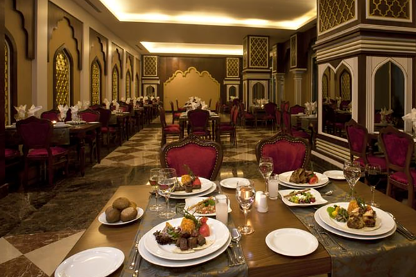 Ein Restaurant des Oz Hotels Side Premium mit eingerichteten Tischen und Speisen.