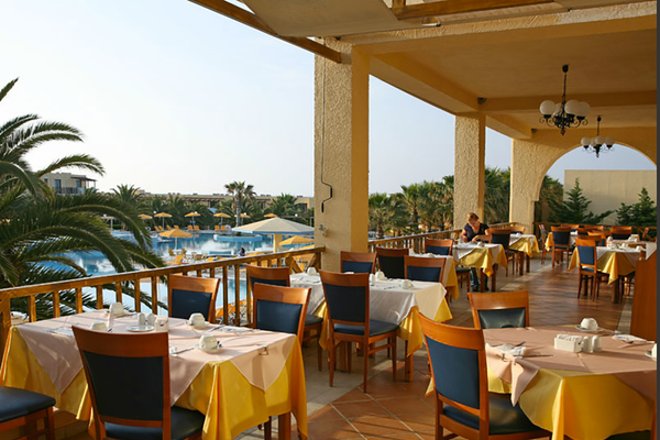 Restaurantterrasse im Porto Bello Beach Hotel mit Blick auf den Pool.