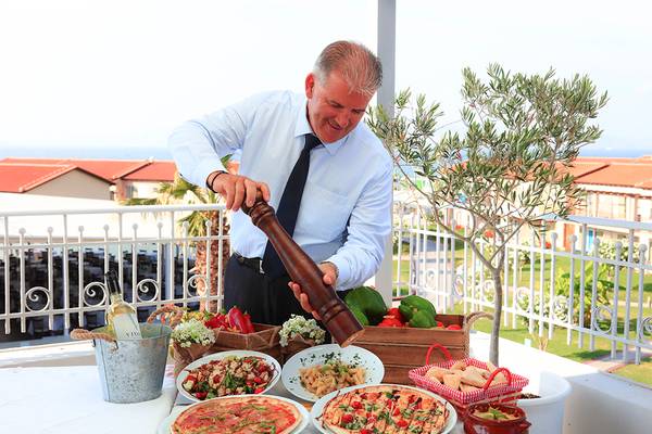 Chef im LABRANDA Marine Aquapark bereitet Mahlzeit auf der Terrasse zu.