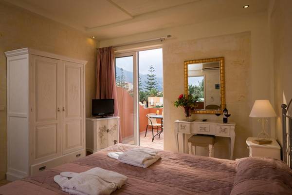 Schlafzimmer im Orpheas Resort mit Terrasse, Fernseher, Schrank und Nachttisch.
