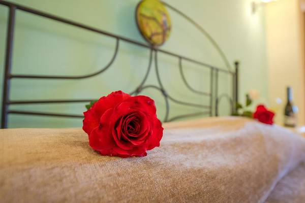 Eine rote Rose liegt auf einem Bett im Orpheas Resort.