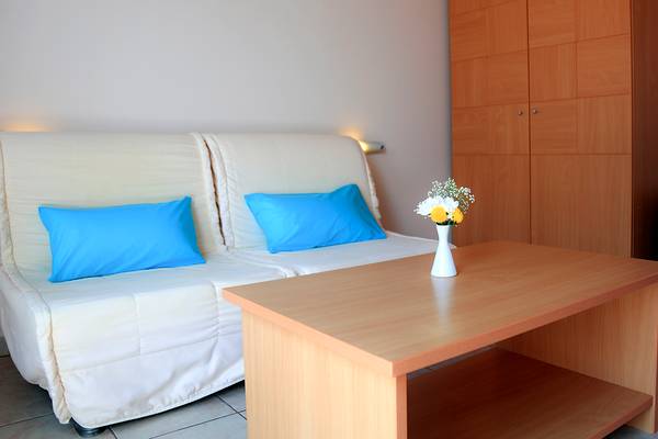 Foto von einem Hotelzimmer mit einem Sofa, einem Tisch und einem Blumenstrauß.