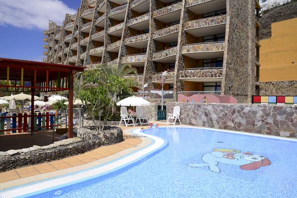 Außenpoolbereich des Gloria Palace Amadores Thalasso & Hotel mit bunten Farben und Gebäuden.