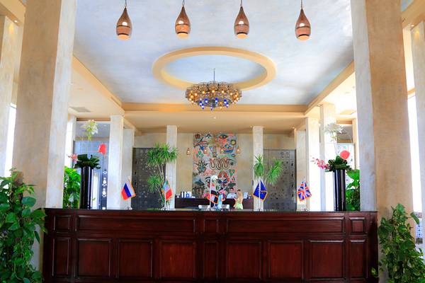 Empfangshalle des Sharm Club Beach Resorts mit hohen Säulen, Kronleuchter und Flaggen.