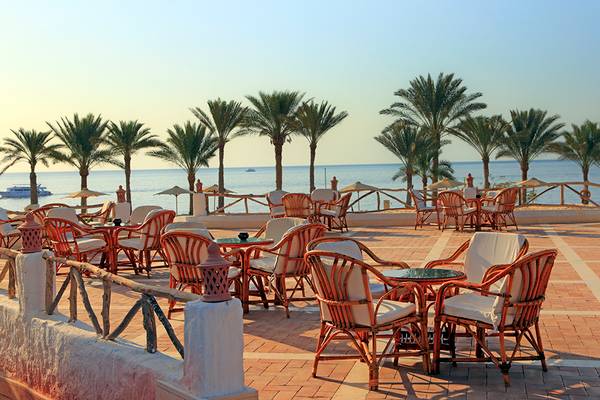 Außenterrasse des Sharm Club Beach Resorts mit Blick auf das Meer und Palmen