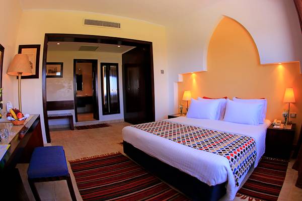 Innenansicht eines Hotelzimmers im Sharm Club Beach Resort mit Doppelbett, Schreibtisch und Dekor