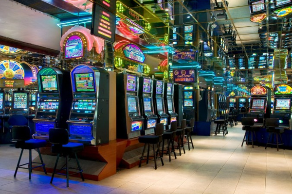 Spielautomaten im Dreams Curacao Resort, Spa & Casino mit blauen Lichtern und Neonschildern.