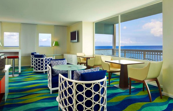 Loungebereich im Dreams Curacao Resort, Spa & Casino mit Blick auf den Ozean und modernen Möbeln.