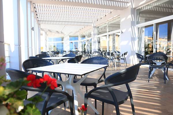 Restaurantterrasse des LABRANDA Kiotari Miraluna Resorts mit Tischen und Stühlen unter einem Pergoladach.