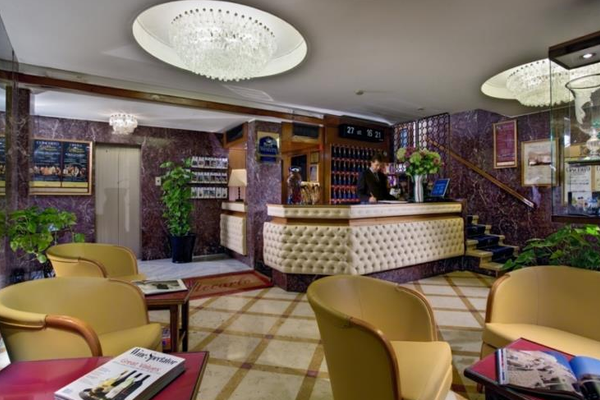 Lobby des Montecarlo Hotels mit Rezeption, Sesseln und Pflanzen.