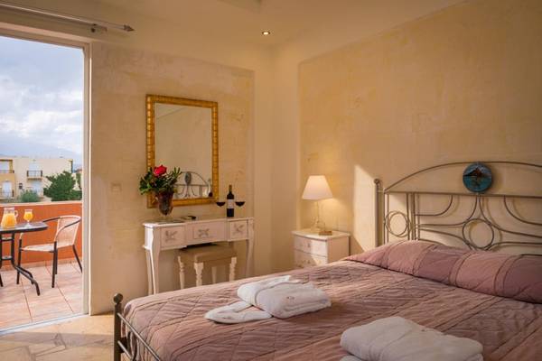 Schlafzimmer im Orpheas Resort mit Blick auf den Balkon und Möbeln.