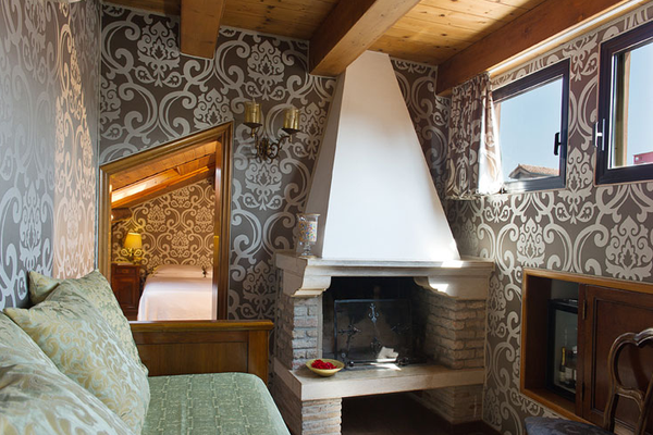 Wohnzimmer im Hotel Casa Nicolo Priuli mit einem Sofa, einem Kamin und gemusterten Wänden.