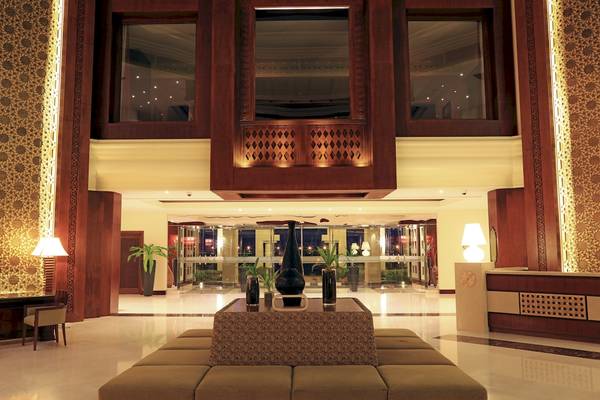 Eingangsbereich des Wyndham Garden Salalah Mirbat Hotel mit Empfang, Sofas und Pflanzen.