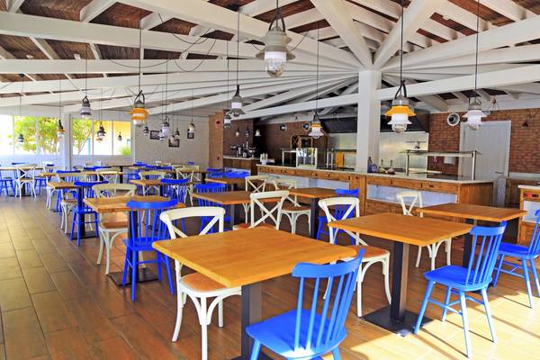Restaurant-Innenbereich des Bluesea Aloe Corralejo mit blauen Stühlen und Holztischen.