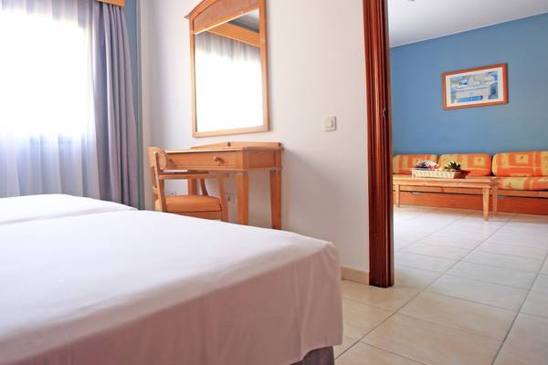 Zimmer im Bluesea Aloe Corralejo Hotel mit zwei Betten, Schreibtisch und Spiegel.