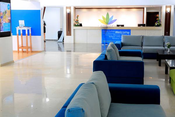 Lobby des Blue Bay Beach Resort mit Sofas, Empfangstresen und Willkommensschild.