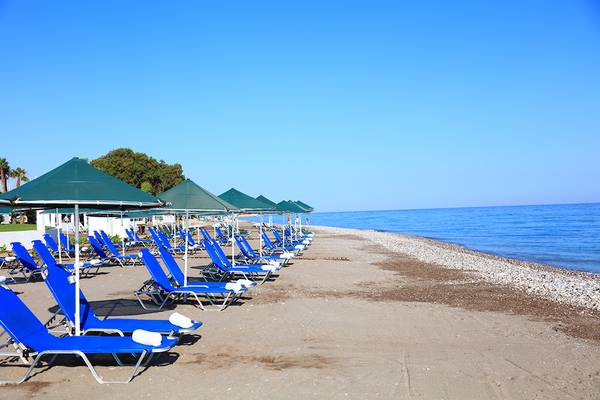 Strand des Blue Bay Beach Resort mit blauen Liegestühlen und grünen Sonnenschirmen