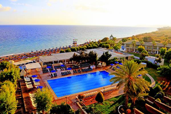 Luftaufnahme des Blue Bay Beach Resorts mit Pool, Liegen und Palmen am Strand