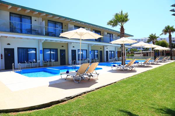 Außenpool und Loungebereich im Blue Bay Beach Resort mit Sonnenliegen und Sonnenschirmen.